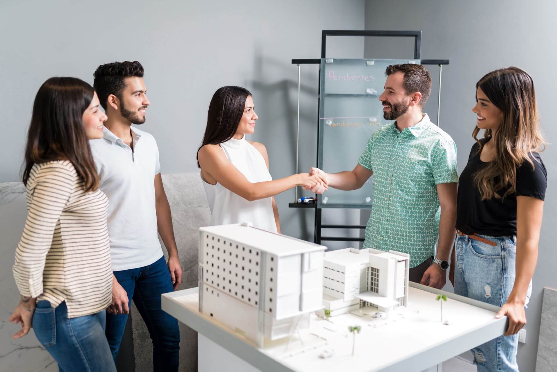 business-partners-shaking-hands-with-engineer-by-architectural-model-meeting